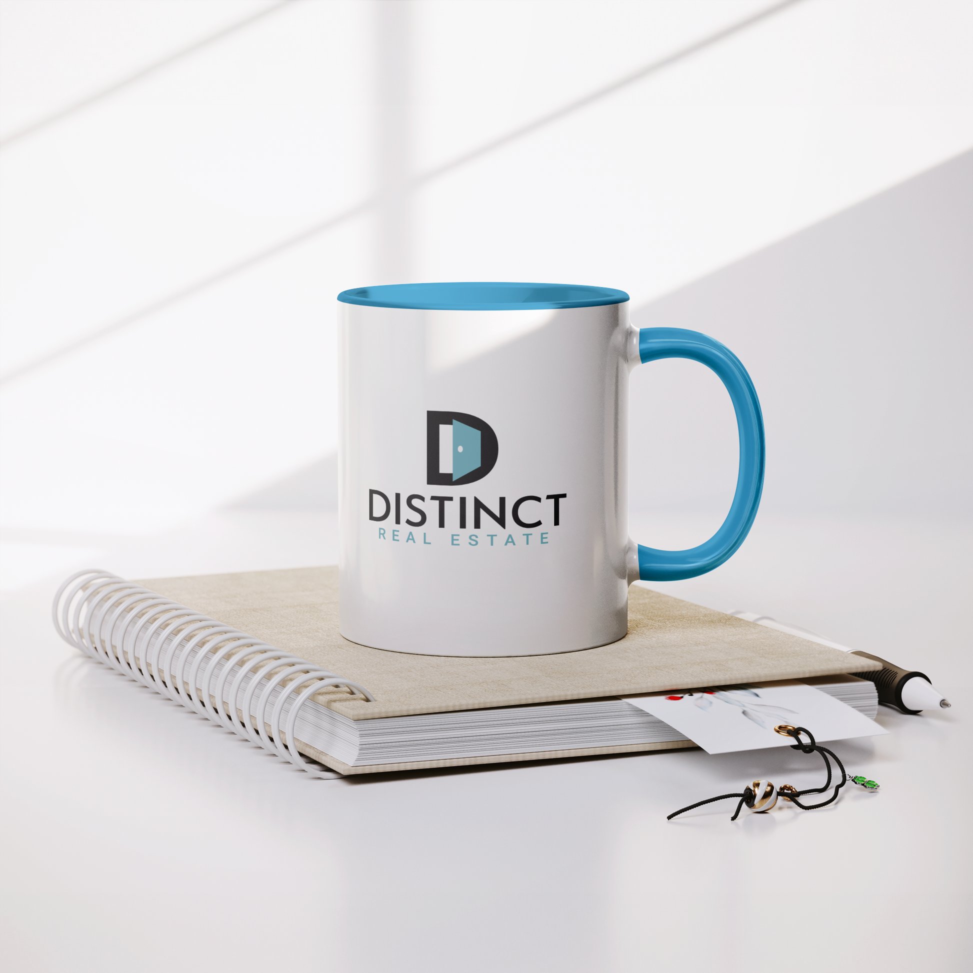 Blue_Accent_White_Mug_with_Stacked_logo_Lifestyle_Notebook_Mockup.png